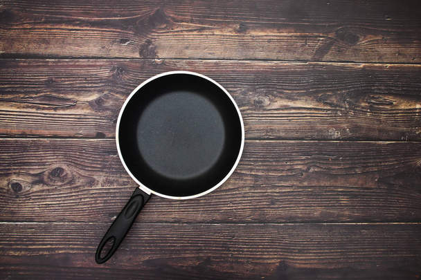 Pan on wooden background  - Фото, изображение