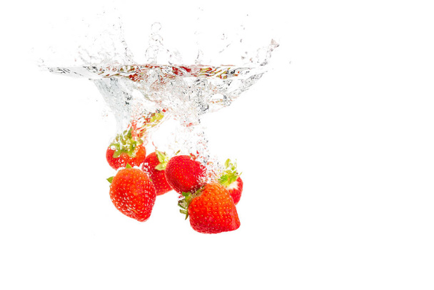 Erdbeeren versinken unter Wasser mit Luftblasen isoliert auf weißem Hintergrund. - Foto, Bild