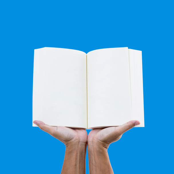 Man hand holding open book on blue screen - Фото, изображение