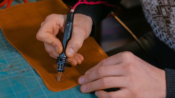 Skinner making decorative details on leather playing field - Foto, Bild