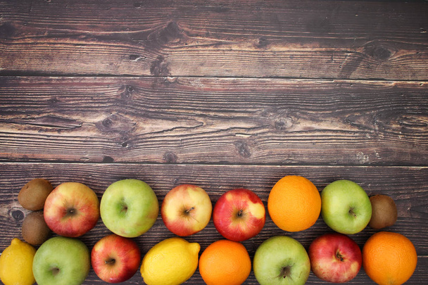 Fresh fruits on the bottom of the wooden background  - Фото, изображение