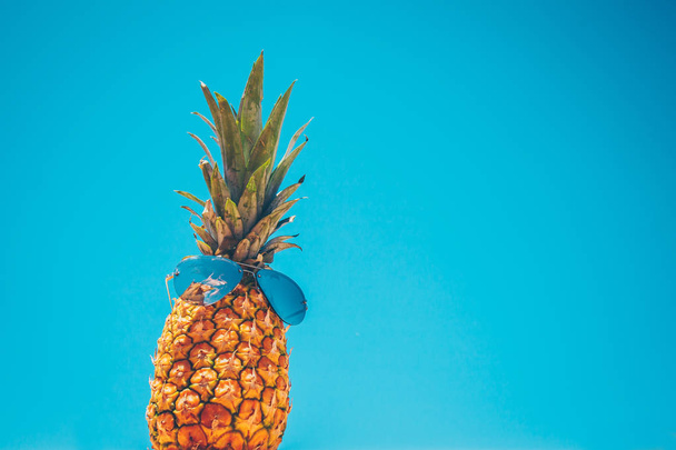 Symbol of tropical vacation - a trip to hot summer countries - pineapple in sunglasses - Foto, immagini