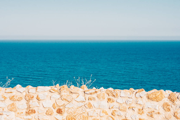 View of the ocean through a stone antique wall - Photo, image