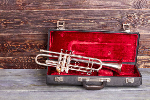 Trumpet on brown wooden background. - Photo, Image