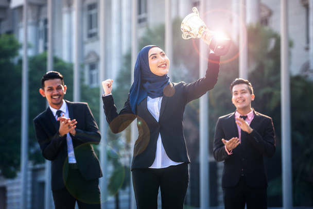 Успішна мусульманська Ділова жінка з обіймами тримає трофей а - Фото, зображення