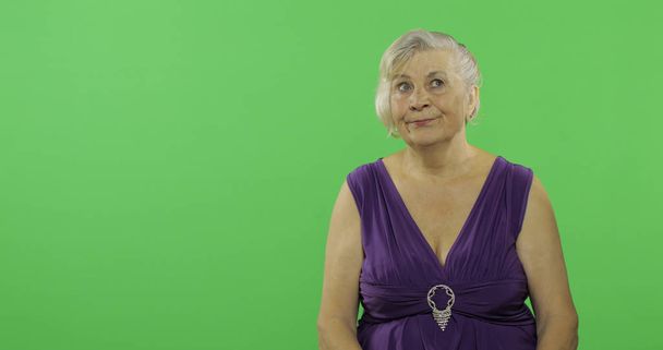 An elderly woman thinks about something. Old thoughtful grandmother. Chroma key - Фото, изображение