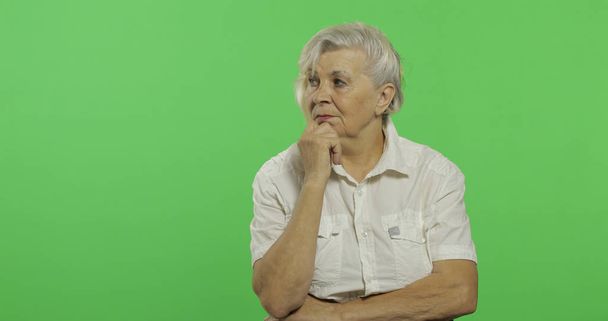 Μια ηλικιωμένη γυναίκα σκέφτεται κάτι. Η παλιά στοχαστική γιαγιά. Πλήκτρο αποχρώσεων - Φωτογραφία, εικόνα