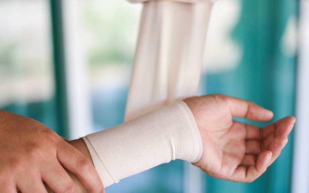 brazo herida vendaje mano y por enfermera / primeros auxilios lesión de muñeca h
 - Foto, Imagen