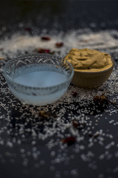 face mask consisting of multani mitti and coconut oil for treatment of suntan in bowls on wooden surface  - Foto, Imagem