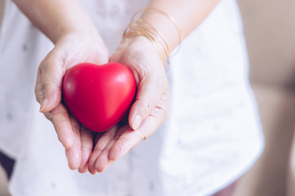 Starsza ręka z raną niosącą czerwone serce. azjatyckie osoby starsze  - Zdjęcie, obraz