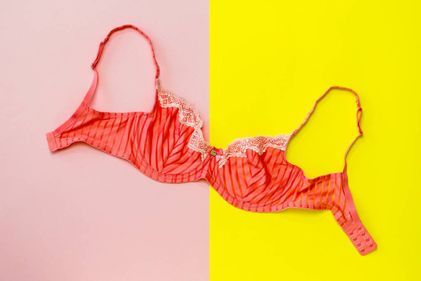 Bright red bra on wooden pink background. Flat lay. - Photo, Image