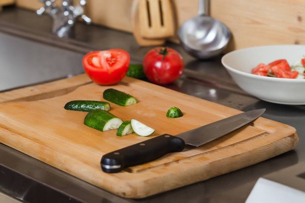Composition with vegetables, cucumbers, tomatoes, knife closeup in the kitchen - 写真・画像