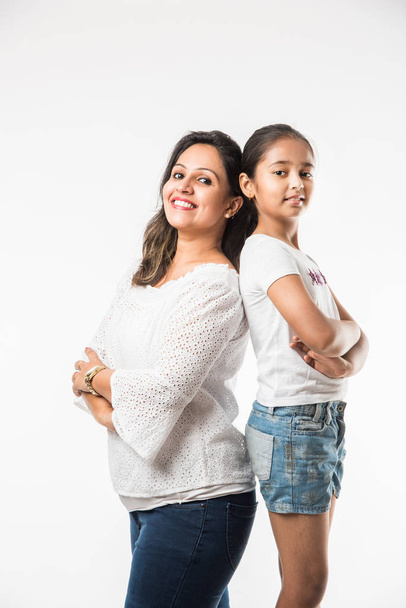Indian mother daughter on white background hugging, kissing, riding, flying, pointing, presenting over white background - Foto, afbeelding