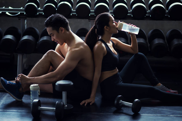 Healthy couple relax after dumbbell exercise - 写真・画像