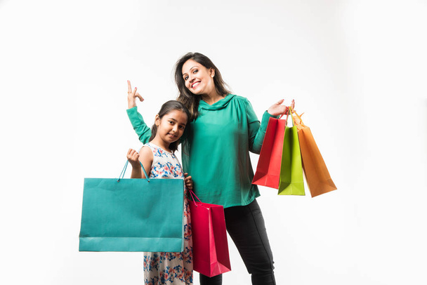 Indyjski/Azji matka córka zakupy i gospodarstwo kolorowe Torby papierowe. Stojący na białym tle - Zdjęcie, obraz