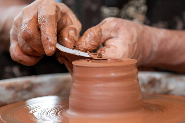 陶芸家は陶器の車輪に陶器の皿を作る - 写真・画像