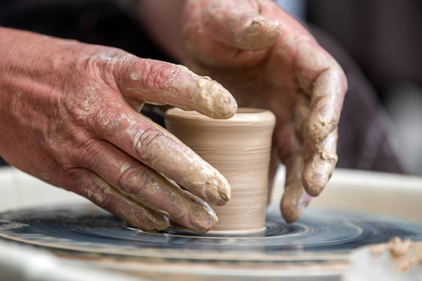 Potter makes pottery dishes on potter's wheel - Foto, Imagem