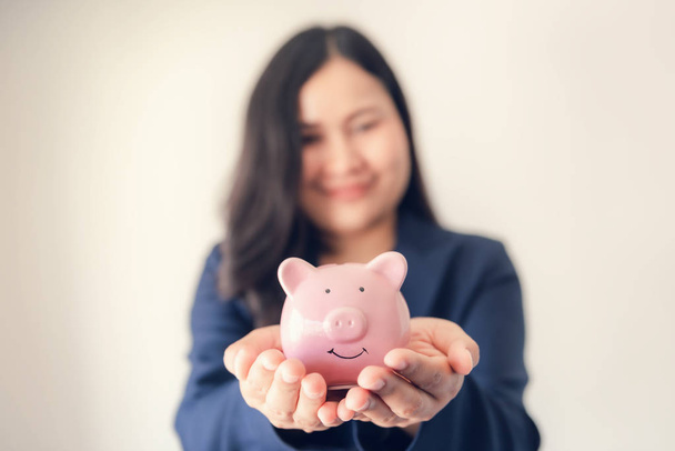 Close Up Portrait of Businesswoman Holding Piggy Bank on Her Hands, Asian Business Woman in Uniform Suit Showing Saving Money While Looking at Camera., Investment and Financial Concept - Photo, Image