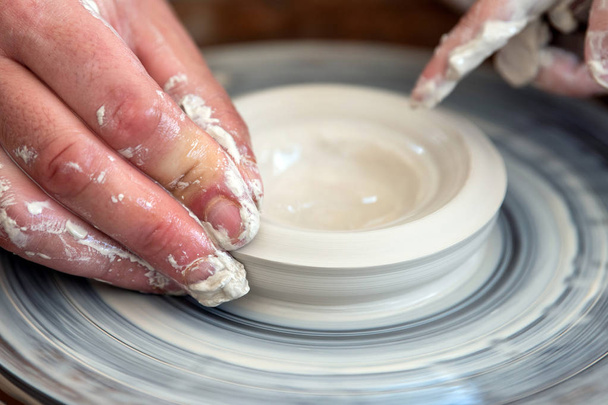 Il vasaio fa piatti di ceramica sulla ruota del vasaio
 - Foto, immagini