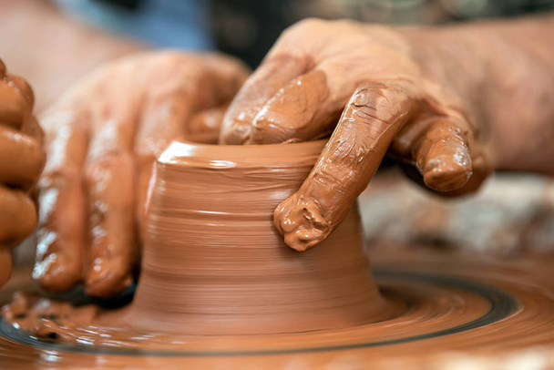 Potter hace platos de cerámica en la rueda del alfarero
 - Foto, imagen