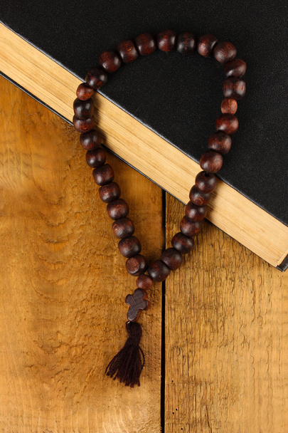 the Wooden rosary beads and holy bible on wooden background close-up - Foto, immagini