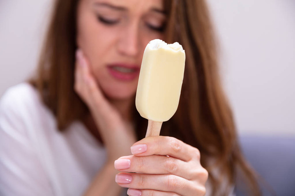 Portrait Of A Woman With Sensitive Teeth And Cold Ice Cream - Foto, afbeelding