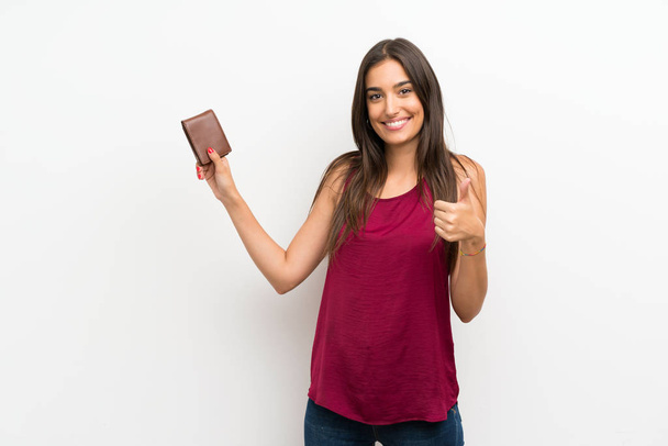 Mladá žena na izolovaném bílém pozadí držící peněženku - Fotografie, Obrázek