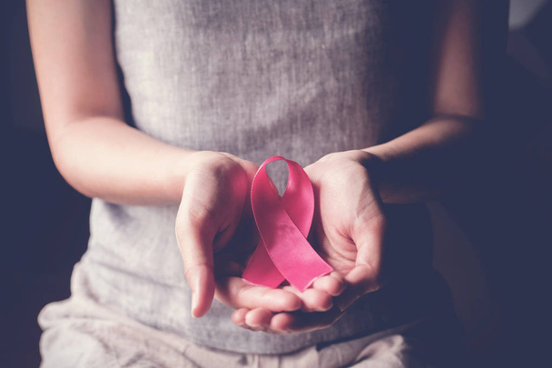 woman holding pink ribbon, breast cancer awareness, October pink - Foto, afbeelding