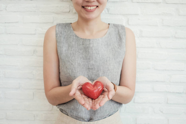 Asian woman holding red heart, health insurance, donation charit - Foto, Imagen