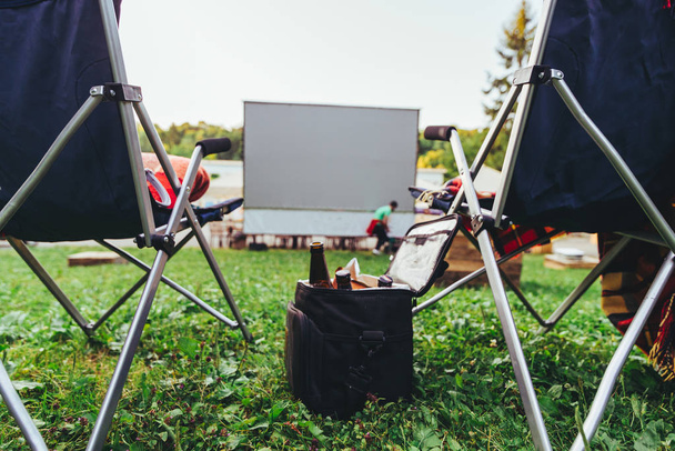 open air cinema concept folding chairs in front of big white screen - Photo, Image