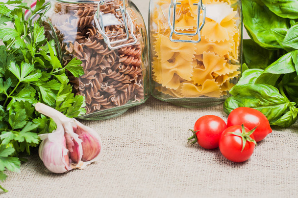 Ingredients for pasta - farfalle and fusilli, garlic, basil, cherry tomato - Fotó, kép