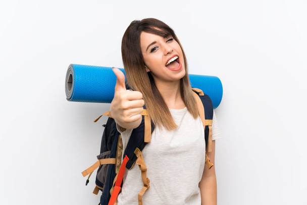 Young traveler woman over white background with thumbs up because something good has happened - Foto, Bild
