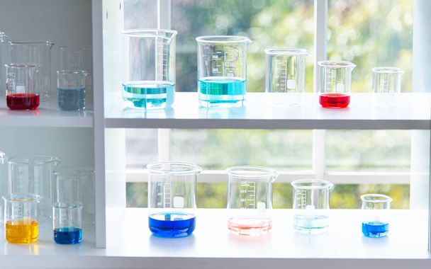 Preparazione di attrezzature da laboratorio come vetreria, tubo con blu e liquido sulla tavola bianca. L'esperimento di chimica nella ricerca scientifica
 - Foto, immagini