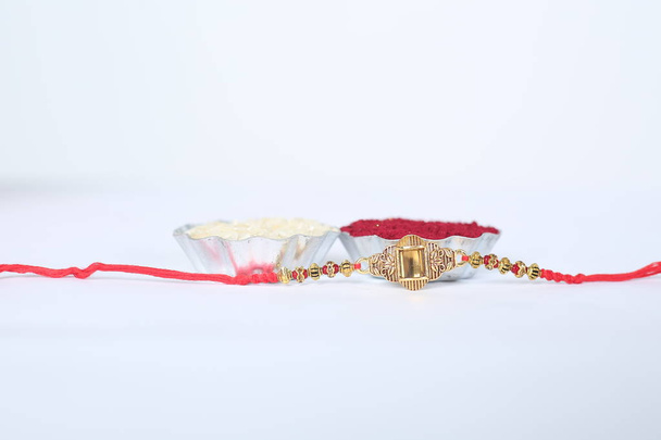 Festival indien : fond Raksha Bandhan avec un élégant Rakhi, Rice Grains et Kumkum. Un bracelet traditionnel indien qui symbolise l'amour entre frères et sœurs. - Photo, image