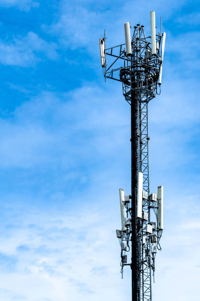 Телекомунікаційна вежа з фоном блакитного неба та білих хмар. Антена на блакитному небі. Радіо і супутниковий полюс. Технології зв'язку. Телекомунікаційна промисловість. Мобільна або телекомунікаційна мережа 4g
. - Фото, зображення