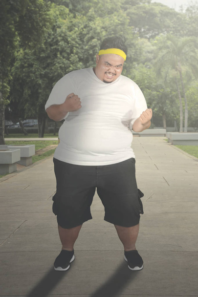 Overweight man looks angry on the path - Foto, Imagen