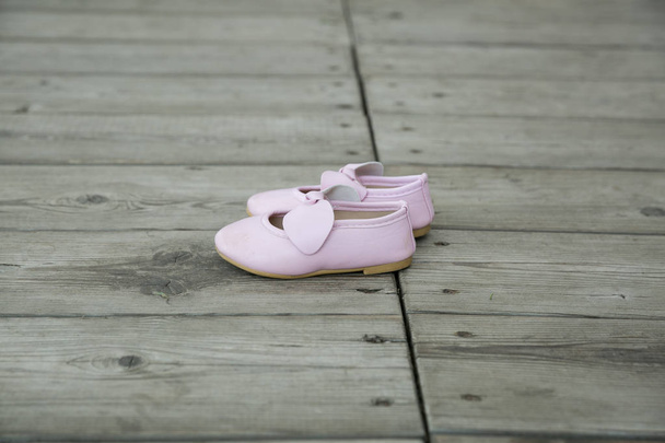 City Cesis, Latvian Republic. Pink baby booties stand on a woode - Photo, Image