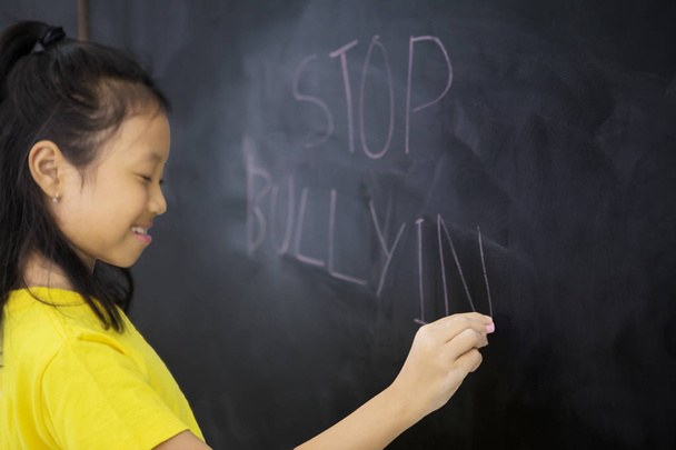 Sad little girl writing a text of stop bullying - Фото, зображення
