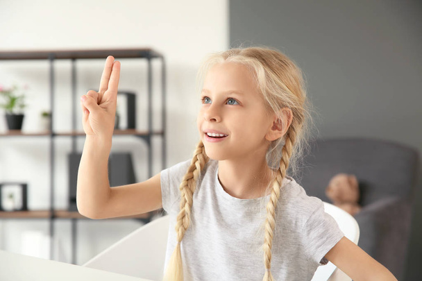 Little deaf mute girl using sign language at home - Fotoğraf, Görsel