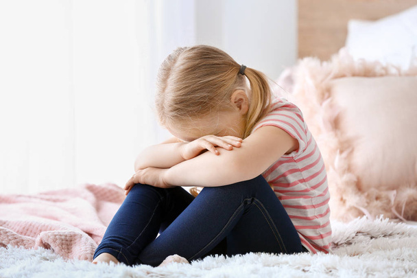 Crying little girl sitting on bed - Fotoğraf, Görsel