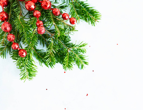 Top uitzicht plat lay natuurlijke kerstboom takken met rood speelgoed, Bow en glas rendieren hoek frame op heldere achtergrond. Nieuwjaar decor concept. Tekstruimte - Foto, afbeelding
