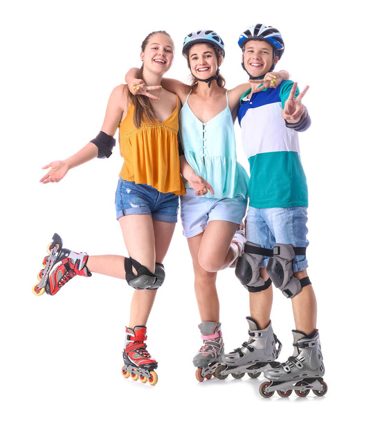 Tieners op rolschaatsen tegen witte achtergrond - Foto, afbeelding