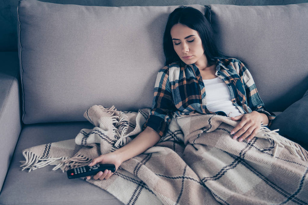 Close up photo beautiful she her lady fell asleep while watching television boredom hands arms hold console covered blanket wear checkered plaid shirt divan flat house living room indoors - Foto, Imagem
