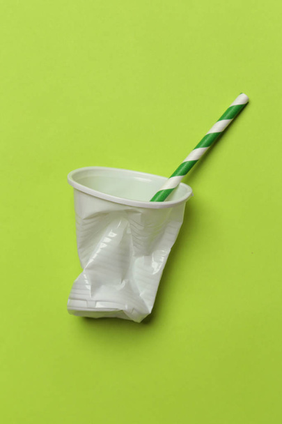 Problema de plástico de uso único - vidro plástico usado e palha de bebida no fundo colorido
 - Foto, Imagem