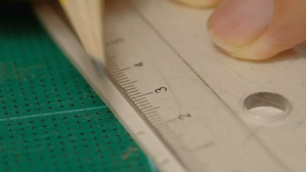 Close-up van mannelijke architect handen tekenen Mark op wit bord met liniaal en potlood. Proces van model maken.  - Video