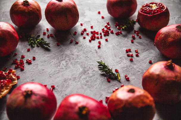 Pomegranate fruit. Ripe and juicy pomegranate on rustic grey background - 写真・画像