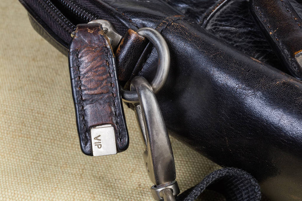 Fragmento de viejo bolso de cuero negro con algunos accesorios de bolsa
 - Foto, Imagen