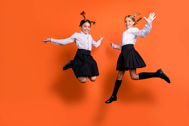 Full length body size view of two person nice attractive lovely charming cute free cheerful cheery pre-teen girls having fun time holiday isolated on bright vivid shine orange background - Foto, immagini