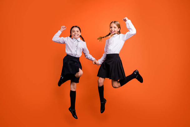 Full length body size view of two person nice trendy attractive charming cute excited cheerful cheery pre-teen girls having fun rejoicing isolated over bright vivid shine orange background - Photo, image