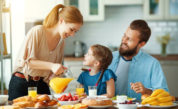 família mãe pai e filho filha tomar café da manhã na cozinha
 - Foto, Imagem